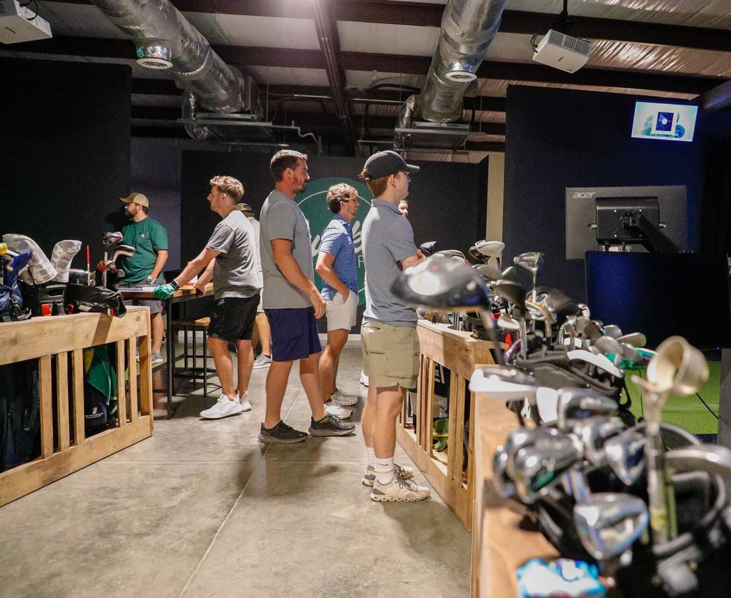Golfers choosing clubs from the club wall at The Links